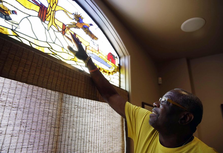 In this March 13, 2014 photo, light filters through a stained glass window depicting a hunting scene onto Dusty Baker at his home in Granite Bay, Calif. Out of uniform for the first time since taking 2007 off between managerial jobs with the Cubs and Reds, Baker is not slowing down much from his pressure-packed days in the dugout. While his sport is still close to his heart despite the sting of his firing after last season in Cincinnati, Baker is working on more than a half-dozen projects at once out of his Sacramento-area home. (AP Photo/Eric Risberg)