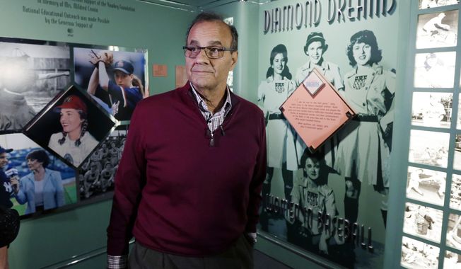 Former New York Yankees manager Joe Torre tours an exhibit on women in baseball during his orientation visit at the Baseball Hall of Fame on Tuesday, March 25, 2014, in Cooperstown, N.Y. Torre will be inducted to the hall in July. (AP Photo/Mike Groll)