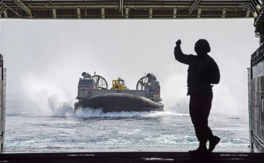 A Sailor directs Landing Craft Air Cushion (LCAC) 90, assigned to Assault Craft Unit (ACU) 5, as it enters the well deck of the amphibious transport dock ship USS Anchorage (LPD 23). (U.S. Navy)