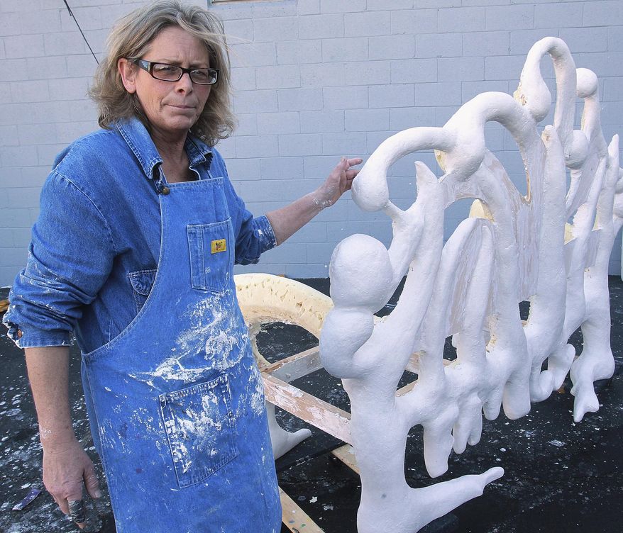 ADVANCE FOR USE SUNDAY, MARCH 30 AND THEREAFTER - In this March 11, 2014 photo, artist Marina Lee, of Milwaukee, poses with the sculpture that Governor French Academy students were assisting her with for the Art on the Square's fourth annual High School Sculpture in the City Program in Belleville, Ill. (AP Photo/Belleville News-Democrat, Tim Vizer)