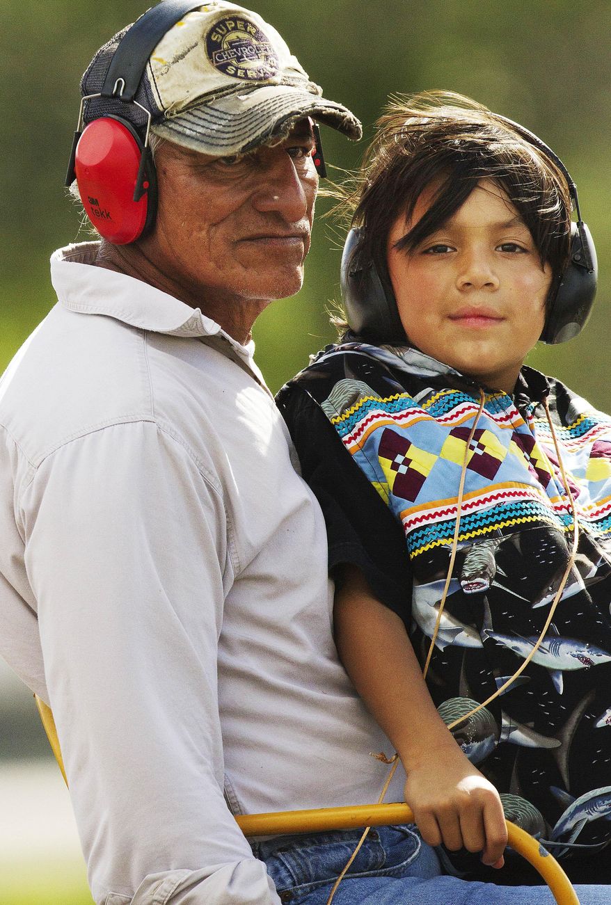 ADVANCE FOR USE SATURDAY, MARCH 29 - in this photo taken on Sept. 27, 2013, Miccosukee tribal member Bobby Tigertail, left, and his grandson, Jonovan Tigertail, 7, take visitors to the Miccusukee Indian Day on airboat rides at the tribal resort and casino in Miami. From a mostly ancient life of hunting, gathering and spiritual ceremonies, modern Indians have mastered the American economic model, building an international casino and resort empire. The challenge is maintaining traditions and protecting the Everglades from further ecological damage while integrating technology and moving even more into the modern world. (AP Photo/The News-Press, Andrew West) MAGS OUT; NAPLES OUT; NO SALES