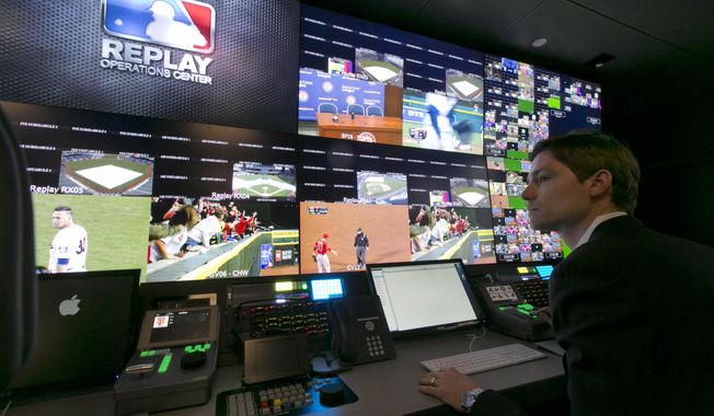 Chris Marinak sits in front of a bank of television screens during a preview of Major League Baseball&#x27;s Replay Operations Center, in New York, Wednesday, March 26, 2014.  Less than a week before most teams open, MLB is working on the unveiling of its new instant replay system, which it hopes will vastly reduce incorrect calls by umpires. (AP Photo/Richard Drew)