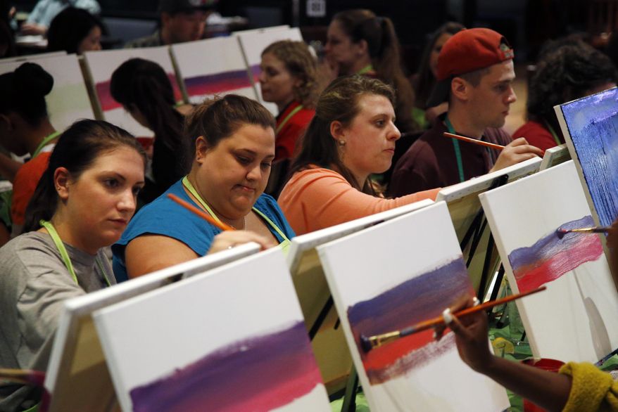 In this Tuesday, March 25, 2014 photo, participants paint a sunset during a Paint Nite event at the Field House sports bar in Philadelphia. Cities like Philadelphia, Boston and New York are offering a creative way to socialize and bring out your inner artist: Paint Nite. A ticket buys you a small canvas, brushes, paints and an easy two-hour lesson at a neighborhood bar. (AP Photo/Matt Slocum)