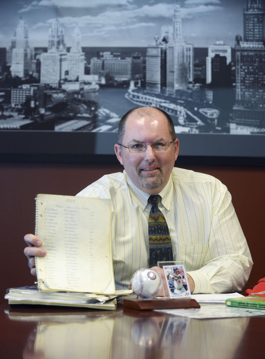 MOVE PHOTO AT 4:00 A.M. CST, WEDNESDAY, MARCH 26 - In this Feb. 25, 2014 photo, Rich Bentel, 47, is seen in his office in Lisle, Ill., holding the original spiral notebook he used from when he started a fantasy baseball league with his high school friend in 1984 while attending Oak Park-River Forest High School. The league is still going strong thirty years later. (AP Photo/Daily Herald, Mark Black) MANDATORY CREDIT, MAGS OUT