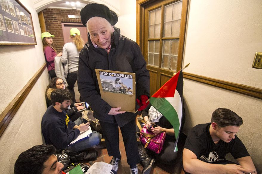 Anne Remley Ann Arbor resident hands out Palestinian flags while students wait in line before being let into the meeting on Tuesday March 25, 2014 in the student Union at the University of Michigan in Ann Arbor, Michigan. The main point of discussion during the meeting was Divestment from Israel. (AP Photo/The Michigan Daily, Adam Glanzman)