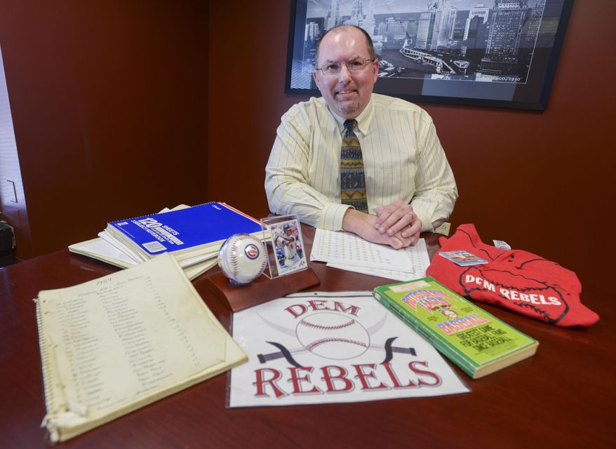 MOVE PHOTO AT 4:00 A.M. CST, WEDNESDAY, MARCH 26 - In this Feb. 25, 2014 photo, Rich Bentel, 47, poses for a photo in his Lisle, Ill., office with memorabilia from when started a fantasy baseball league with his high school friend in 1984 while attending Oak Park-River Forest High School. The league is still going strong thirty years later. (AP Photo/Daily Herald, Mark Black) MANDATORY CREDIT, MAGS OUT