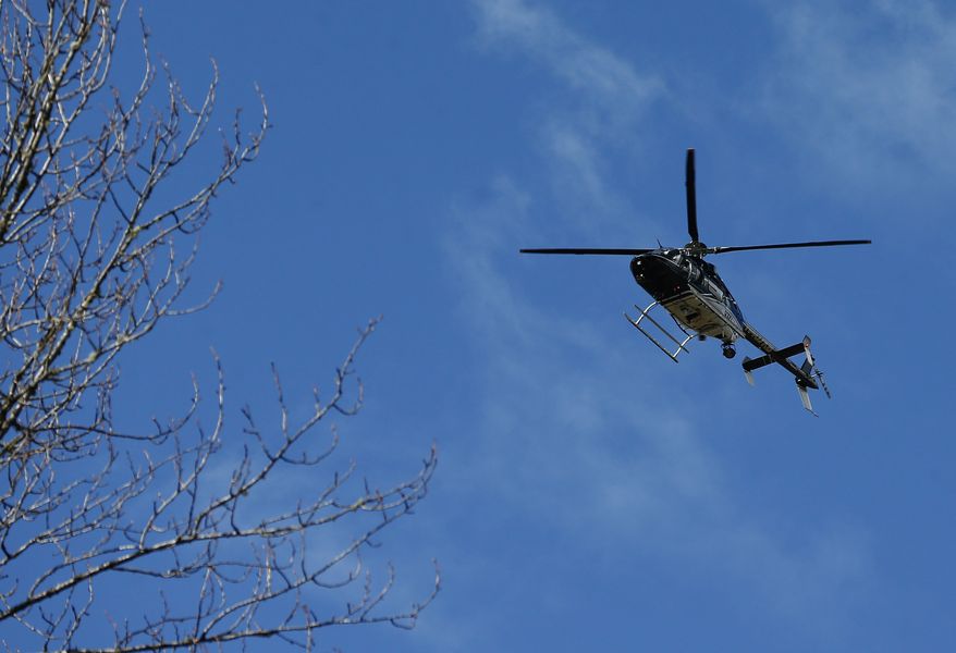 A Snohomish County Sheriff helicopter flies over the scene on Highway 530 next to mile marker 37 on Sunday, March 23, 2014, the day after a giant landslide occurred near mile marker 37 near Oso, Washington. At least six homes have been washed away, with three people reported dead so far and at least eighteen missing. The nearby Stillaguamish River has been dammed up by 15-20 feet of debris as a result, creating more flooding concerns, as reported by KING 5 via the state hydrologist. (AP Photo/The Seattle Times, Lindsey Wasson, Pool)
