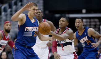 Washington Wizards Bradley Beal (3) passes the ball while Phoenix Suns&#39; Alex Len (21) and Gerald Green (14) defend during the first half of an NBA basketball game in Washington, Wednesday, March 26, 2014. (AP Photo/Manuel Balce Ceneta)