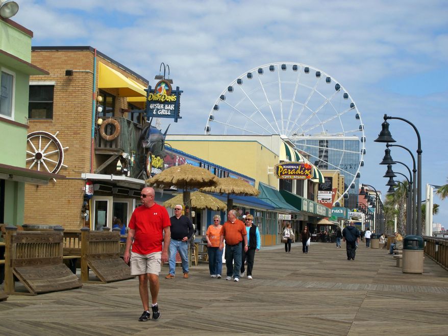 FILE - Visitors walk along the boardwalk in downtown Myrtle Beach, S.C., in this March 7, 2012 file photo. The U.S. Census Bureau announced on Thursday, March 27, 2014 that South Carolina's population is approaching 4.8 million and the Myrtle Beach-Conway-North Myrtle Beach area in South Carolina along with Brunswick County, N.C. is the seventh fastest-growing metropolitan area in the nation. (AP Photo/Bruce Smith, file).