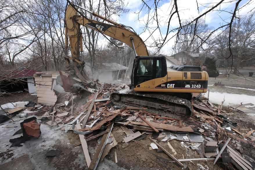 A excavator tears down a house in Detroit’s Brightmoor area Monday, March 24, 2014, in Detroit. For years, Brightmoor area residents pleaded with the city to demolish vacant homes that scavengers have stripped of wiring and plumbing and anything of value. Some structures are already gone, and now officials aim to do much more, possibly tearing down as many as 450 empty houses each week across more than 20 square miles of this bankrupt city _ a vast patchwork of rotting homes comparable to the size of Manhattan. (AP Photo/Paul Sancya)