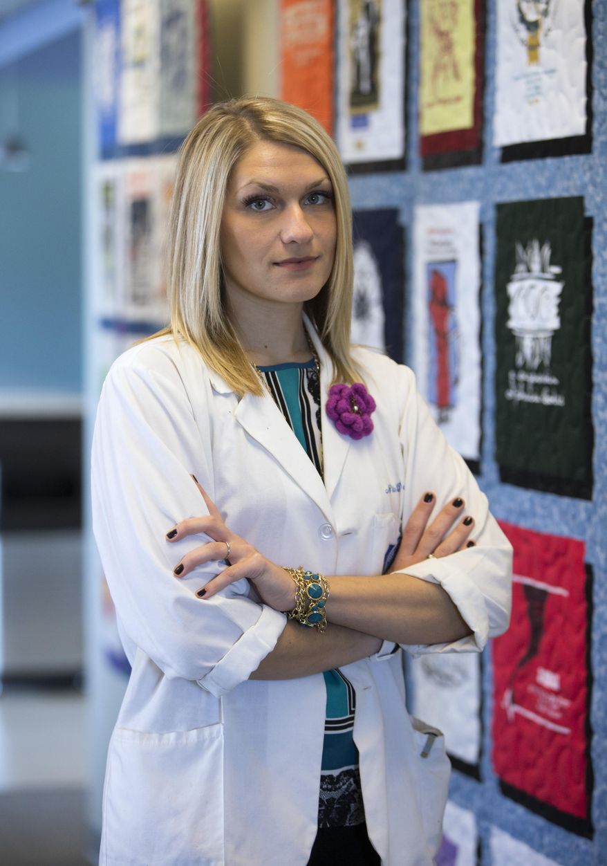 In this March 26, 2014 photo, Nida Degesys, National President of the American Medical Student Association, poses for photos in her office in Sterling, Va. Degesys graduated in May 2013 from Northeast Ohio Medical University with about $180,000 in loans. The amount has already swelled with interest to about $220,000. Yet, as costly as medical school was, Degesys sees it as an investment in herself and her career, one she thinks will pay off with a higher earning potential. (AP Photo/Evan Vucci)