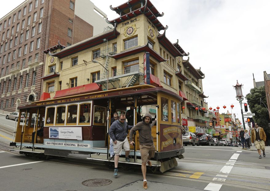 Passengers disembark a cable car in the Chinatown district Thursday, March 27, 2014, in San Francisco. Beneath the strings of red paper lanterns and narrow alleyways of the nation's oldest Chinatown lies an underworld, a place with a history of opium dens, gambling houses and gangland murders. Federal investigators say it's also where Raymond "Shrimp Boy" Chow operated a criminal empire while projecting a public image of community servant. The allegations against Chow are part of an FBI sting that names 25 other defendants, including state Sen. Leland Yee. (AP Photo/Ben Margot)