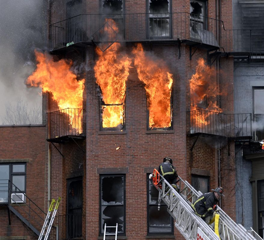 Boston firefighters work a multi-alarm brownstone fire, Wednesday, March 26, 2014, in Boston. A Boston city councilor said two firefighters have died in a fire that ripped through the brownstone. (AP Photo/The Boston Herald, Christopher Evans) BOSTON GLOBE OUT; METRO BOSTON OUT; MAGAZINES OUT; ONLINE OUT.