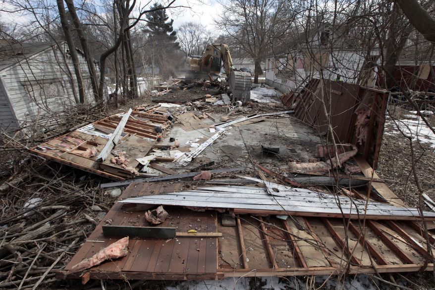 A excavator tears down a house in Detroit’s Brightmoor area Monday, March 24, 2014, in Detroit. For years, Brightmoor area residents pleaded with the city to demolish vacant homes that scavengers have stripped of wiring and plumbing and anything of value. Some structures are already gone, and now officials aim to do much more, possibly tearing down as many as 450 empty houses each week across more than 20 square miles of this bankrupt city _ a vast patchwork of rotting homes comparable to the size of Manhattan. (AP Photo/Paul Sancya)