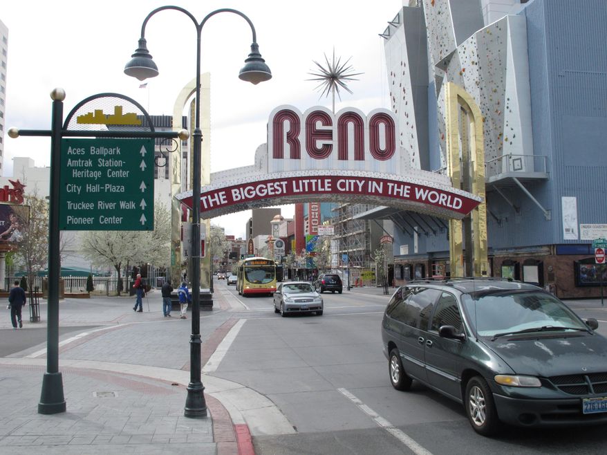 Pedestrians and traffic on Virginia Street on Thursday, March 27, 2014, in downtown Reno, Nev., where local tourism officials say visitors spent more money and stayed longer last year than they did two years ago. The Reno-Sparks Convention and Visitors Authority said a new survey shows gamblers still drive the Reno-Tahoe market but outdoor recreation and sightseeing in the Sierra are bringing more families and others to the region. (AP Photo/Scott Sonner)