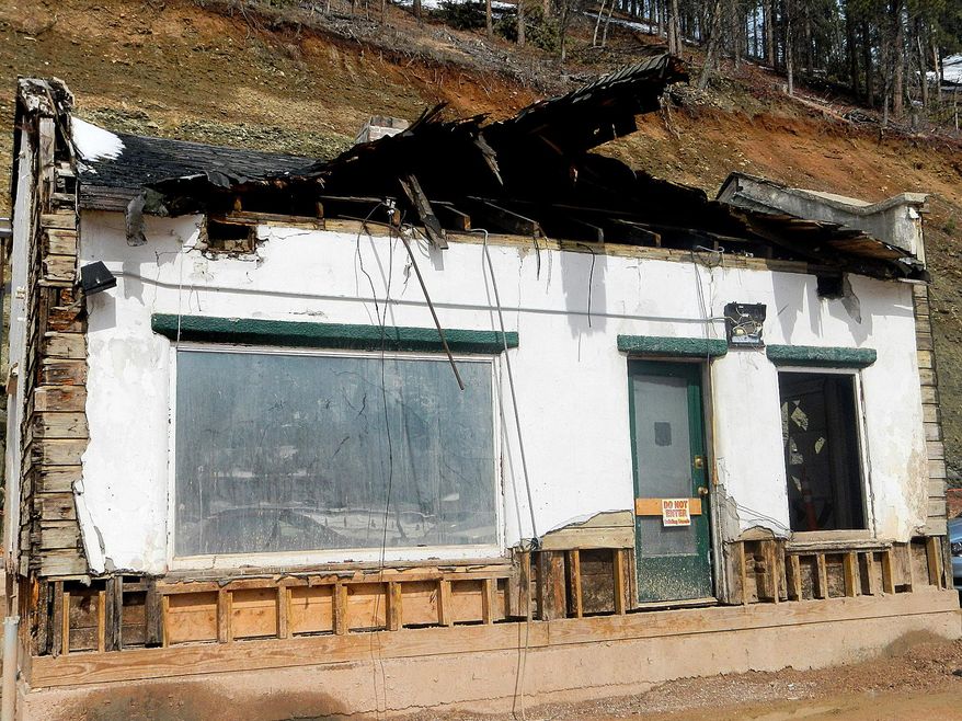 This March 26, 2014 photo shows the 1927 Sinclair filling station in Deadwood, S.D. The Deadwood Historic Preservation Commission is allowing the removal of the historic building to make way for more casino parking in the western South Dakota gambling town, ending a dispute that has lingered for years and ended up in the courts. First Gold Hotel first sought to demolish the vacant Sinclair filling station on its property after acquiring it in 2006. The 1927 building is listed on the National Register of Historic Places, but the hotel says it was heavily damaged by an October 2013 blizzard and is now beyond repair. (AP Photo/Tom Griffith, Rapid City Journal)