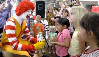 FILE - In this file photo taken May 18, 2006, Ronald McDonald visits with children at a McDonald&#x27;s Restaurant in Roswell, N.M. Taco Bell is using real-life people named Ronald McDonald in a marketing campaign to promote its new breakfast menu, a nod to the famous clown known for his bright red hair and a yellow jumpsuit. The chain is hoping to go after McDonald’s, the No. 1 player in breakfast. (AP Photo/Roswell Daily Record, Andrew Poertner, File)
