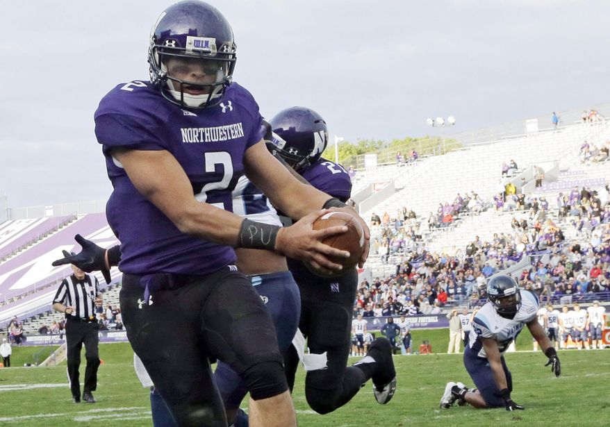 FILE - In this Sept. 21, 2013 file photo, Northwestern quarterback Kain Colter (2), wears APU for "All Players United" on wrist tape as he scores a touchdown during an NCAA college football game against Maine in Evanston, Ill. The decision to allow Northwestern football players to unionize raises an array of questions for college sports. Among them, state schools vs. public schools, powerhouse programs vs. smaller colleges. (AP Photo/Nam Y. Huh, File)