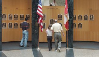 This April 30, 2004 file photo shows museum patrons viewing plaques of recent inductees into the National Baseball Hall of Fame and Museum in Cooperstown, N.Y.  There are many destinations of interest to baseball fans around the country outside ballparks from museums and statues to historic homes. (AP Photo/Tim Roske, File)