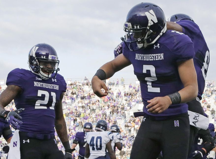 FILE - In this Sept. 21, 2013 file photo, Northwestern quarterback Kain Colter (2) wears APU for "All Players United" on wrist tape while celebrates with running back Stephen Buckley (8) and wide receiver Kyle Prater (21) after scoring a touchdown in an NCAA college football game against Maine in Evanston, Ill. The decision to allow Northwestern football players to unionize raises an array of questions for college sports. Among them, state schools vs. public schools, powerhouse programs vs. smaller colleges. (AP Photo/Nam Y. Huh, File)