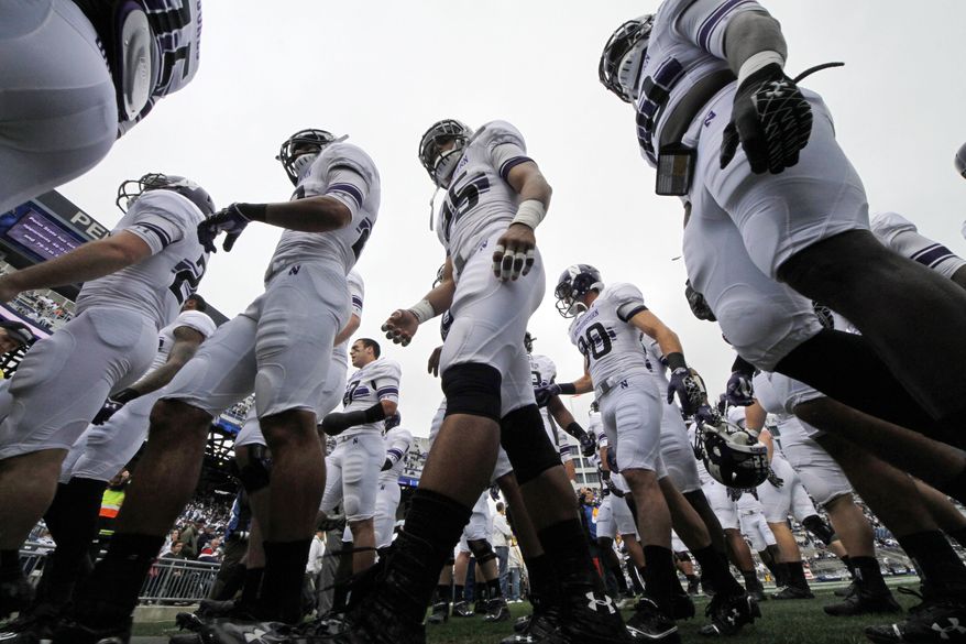 FILE - In this Saturday, Oct 6, 2012, file photo, the Northwestern football team heads to the locker room after warming up before an NCAA college football game against Penn State in State College, Pa. A ruling Wednesday, March 26, 2014, that the Northwestern football team can bargain with the school as employees represented by a union may not by itself change the way amateur sports operate. But it figures to put more pressure on the NCAA and the major conferences to give something back to the players to justify the billions of dollars the players bring in _ and never see. (AP Photo/Gene J. Puskar, File)