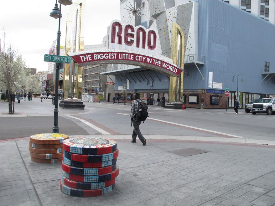 Tourists and locals walk on Virginia Street on Thursday, March 27, 2014, in downtown Reno, Nev., where local tourism officials say visitors spent more money and stayed longer last year than they did two years ago. The Reno-Sparks Convention and Visitors Authority said a new survey shows gamblers still drive the Reno-Tahoe market but outdoor recreation and sightseeing in the Sierra are bringing more families and others to the region. (AP Photo/Scott Sonner)