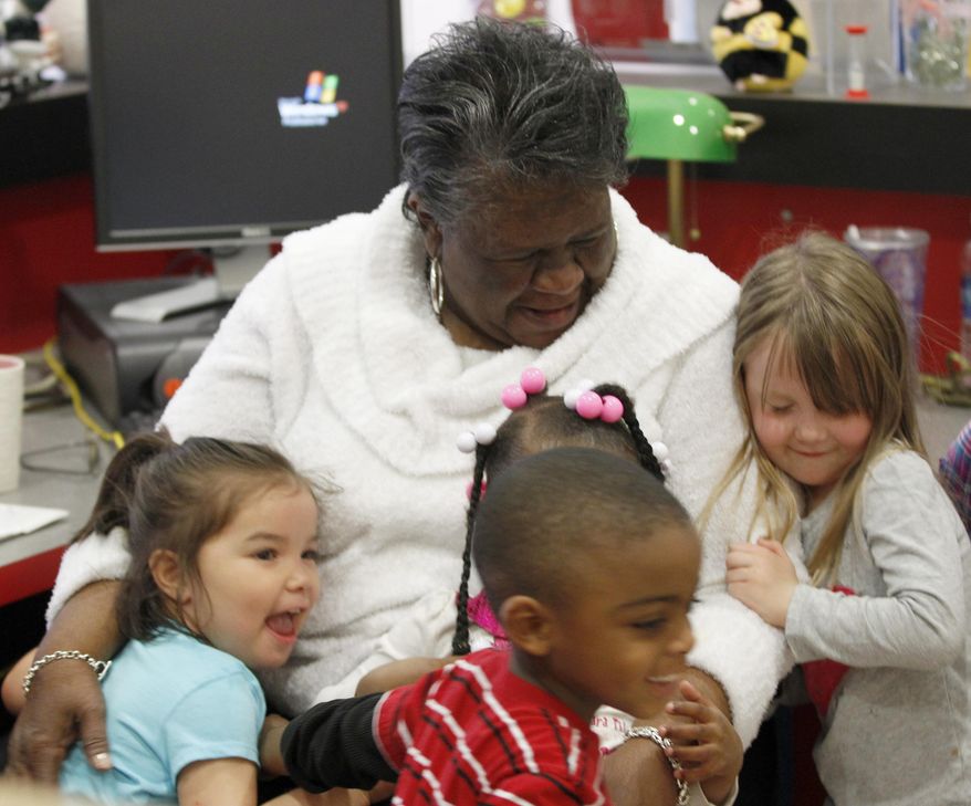 ADVANCED FOR USE SUNDAY, MARCH 30, 2014, AND THEREAFTER - In this March 19, 2014 photo, Mildred Johnson hugs several children who were passing her desk in the lobby of the South Fant Early Childhood Education Center in Anderson, S.C. Johnson says she gives a hug to every child that wants one as they enter the school in the morning. (AP Photo/The Independent-Mail, Sefton Ipock) THE GREENVILLE NEWS OUT, SENECA NEWS OUT