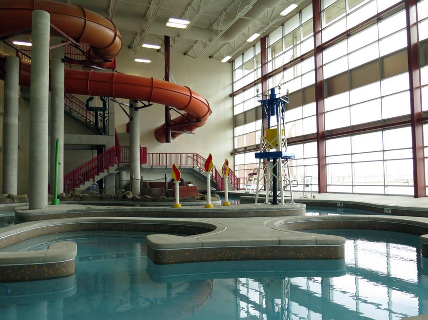 In this March 27, 2014 photo an oil derrickand the flames of gas fires decorate an indoor water park at a new recreation center in oil-rich Williston, North Dakota. The city hopes the center will help draw families to North Dakota's oil patch. (AP Photo/Josh Wood)