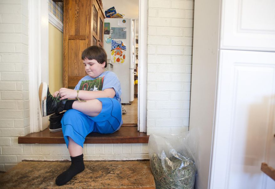 Sunnie Kahle, 8, puts on her shoes before leaving her home in Forest, Va. on March 26, 2014. Kahle recently withdrew from Timberlake Christian School in Forest, Va. after the school sent a letter asking her to either dress and act more feminine or not enroll again because she looked too much like a boy. (AP Photo/The News & Advance, Jill Nance)