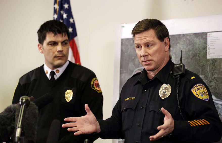 Snohomish County District 21 Fire Chief Travis Hots, left, looks on as Everett police Lt. Robert Goetz speaks to wrap-up a news conference about a deadly mudslide Friday, March 28, 2014, in Arlington, Wash. The death toll from the mudslide in nearby Oso, Wash., is expected to rise considerably within days as the Snohomish County Medical Examiner's Office catches up with the recovery effort, officials said. (AP Photo/Elaine Thompson)