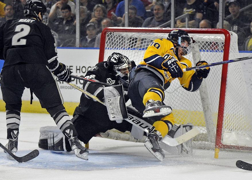 Quinnipiac's Connor Jones is knocked into Providence goalkeeper Jon Gillies during the second period of an NCAA men's East Regional hockey tournament Friday, March 28, 2014, in Bridgeport, Conn. (AP Photo/Fred Beckham)
