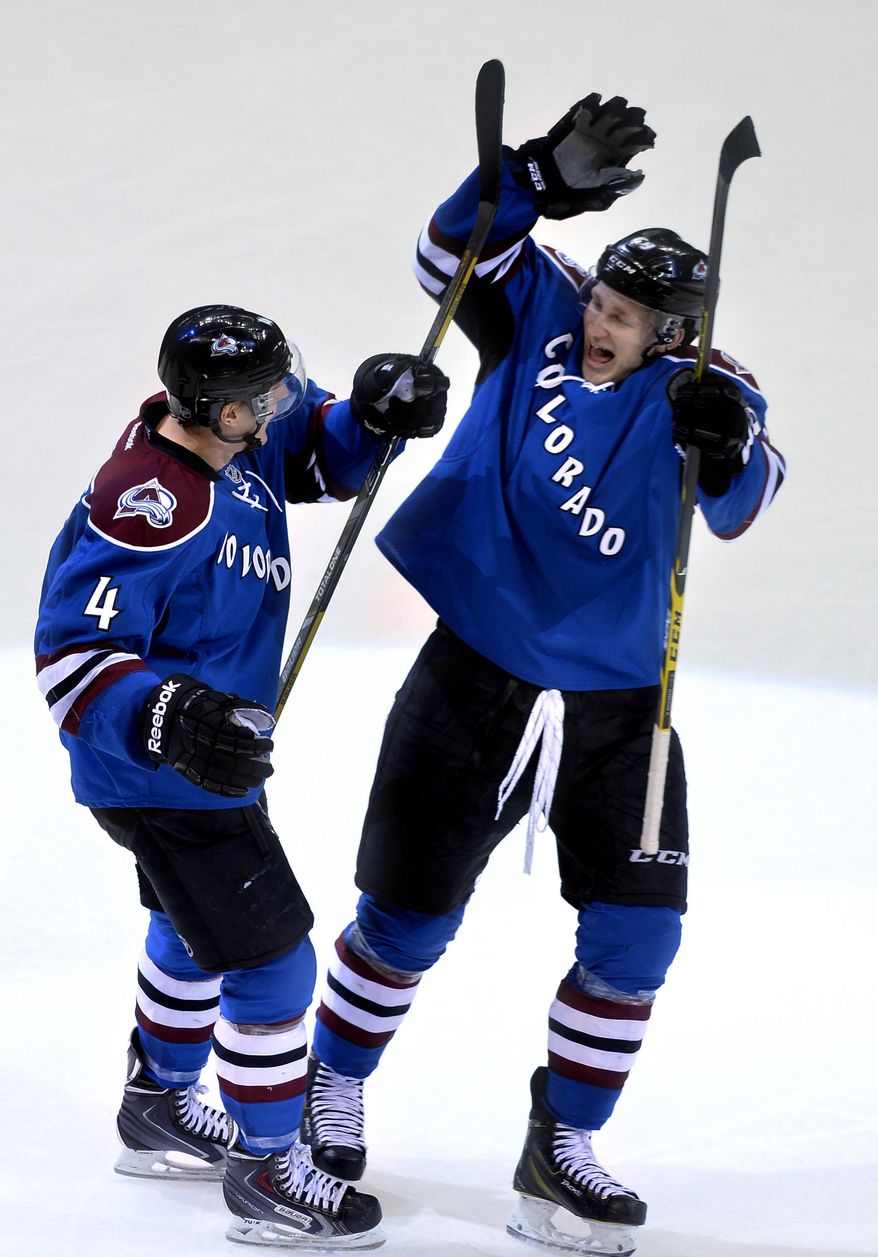 Colorado Avalanche defenseman Tyson Barrie (4) is congratulated by Nathan MacKinnon after scoring in overtime against the Vancouver Canucks during an NHL hockey game, Thursday, March 27, 2014, in Denver. Colorado won 3-2. (AP Photo/Jack Dempsey)
