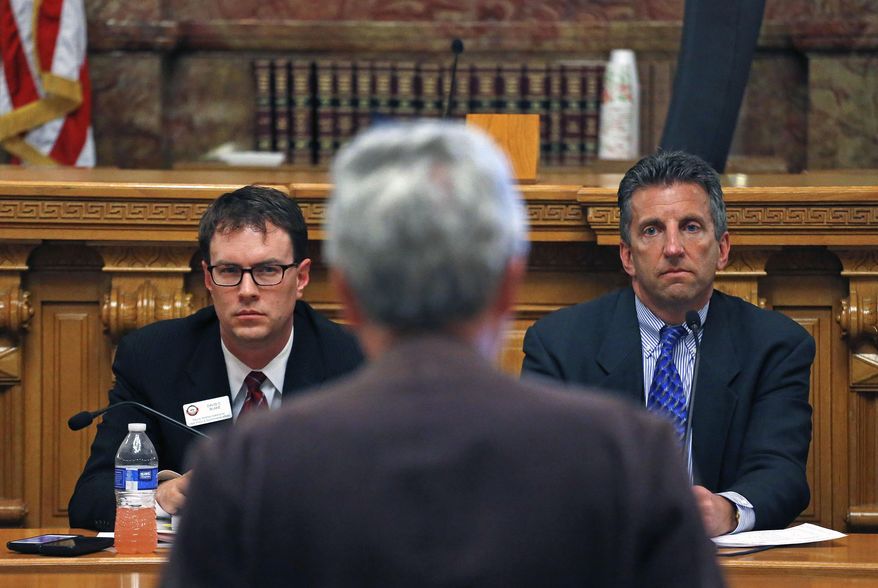 Dr. Larry Wolk, right, the Executive Director and Chief Medical Officer for the Colorado Department of Public Health and Environment, and David Blake, Colorado Deputy Attorney General, listen to comments by Mark Pedersen, of the Cannabis Patient Network Institute, during a marijuana town hall meeting at the Capitol in Denver, Friday March. 28, 2014. The meeting was held to gauge opinions on closing a legal loophole for medical marijuana caregivers. (AP Photo/Brennan Linsley)