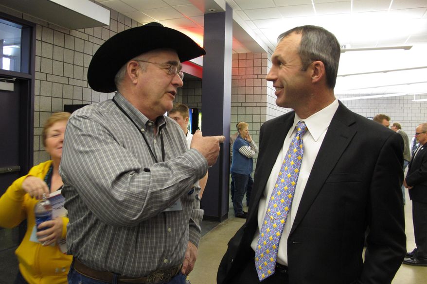 North Dakota Democratic convention delegate Dean Meyer, left, talks with the party's nominee for state agriculture commissioner, Ryan Taylor, during events Friday, March 28, 2014, in Fargo, N.D. (AP Photo/Dave Kolpack)