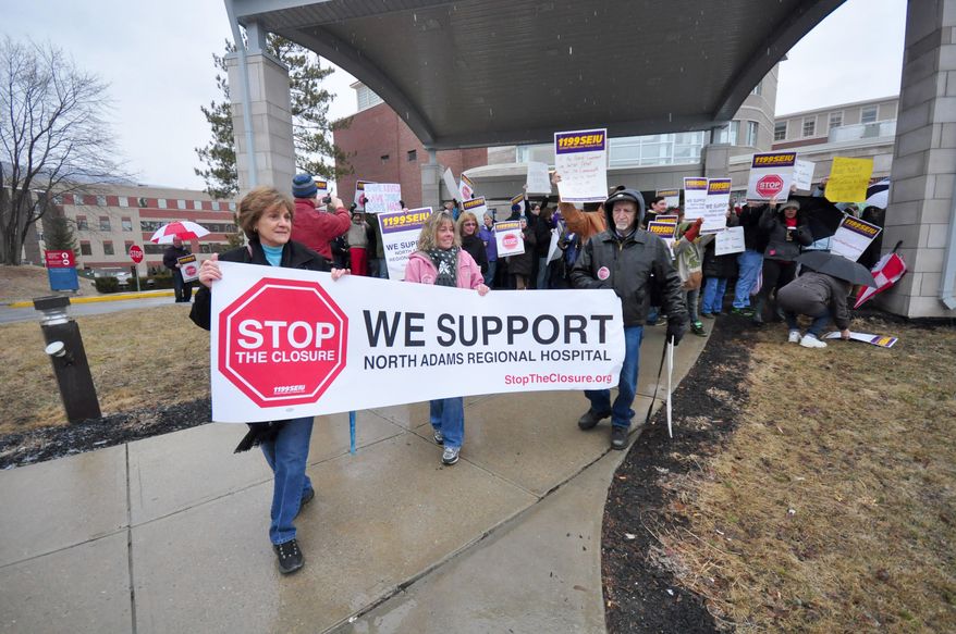 More than 100 demonstrators stand outside to protest the closing of North Adams Regional Hospital, on Friday, March 28, 2014, in North Adams, Mass. The hospital announced the closure of the community hospital, on Tuesday. (AP Photo/The Berkshire Eagle, Gillian Jones)