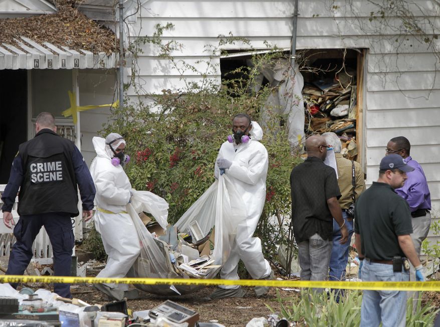 Hazardous materials contractors for the city remove debris from the home where a body was found in the 6200 block of Martel Avenue in Dallas, Texas on Thursday, March 27, 2014. Dallas fire and police departments started searching the house following a welfare check on Saturday. Due to the circumstances the City Attorney’s office was contacted to obtain a warrant to provide a removal process of the debris from inside the home. A contractor was secured to begin the removal process. On Thursday the contractors reported that they had found a dead body inside the home. (AP Photo/The Dallas Morning News, Brad Loper)