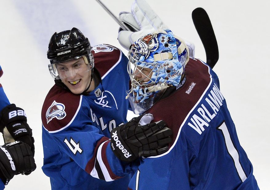 Colorado Avalanche defenseman Tyson Barrie (4) is congratulated by Semyon Varlamov (1) after scoring in overtime against the Vancouver Canucks during an NHL hockey game, Thursday, March 27, 2014, in Denver. Colorado won 3-2. (AP Photo/Jack Dempsey)