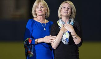 Sandy Carter, left, wife of former Montreal Expos Gary Carter, and her daughter Kimmy acknowledge applauds from the crowd during a ceremony prior to a pre-season game between the Toronto Blue Jays and the New York Mets Friday, March 28, 2014 in Montreal.  (AP Photo/The Canadian Press, Paul Chiasson)