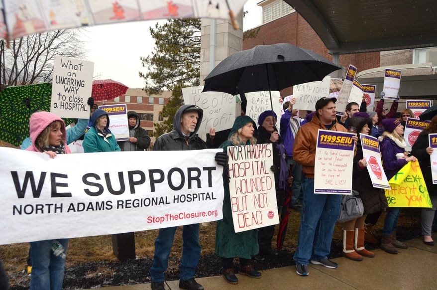 More than 100 demonstrators stand outside to protest the closing of North Adams Regional Hospital, Friday, March 28, 2014, in North Adams, Mass. The hospital announced the closure of the community hospital on Tuesday. (AP Photo/The Berkshire Eagle, Gillian Jones)