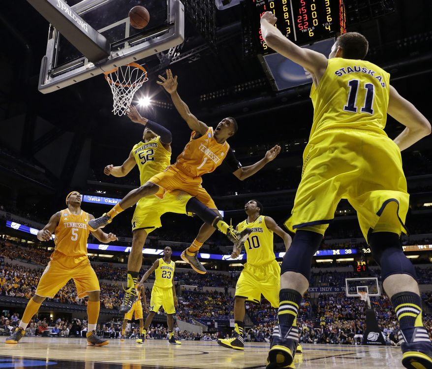 Tennessee's Josh Richardson (1) Michigan's Jordan Morgan (52) go after a loose ball during the first half of an NCAA Midwest Regional semifinal college basketball tournament game Friday, March 28, 2014, in Indianapolis. (AP Photo/Michael Conroy)