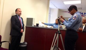 Businessman Mark Witaschek submits to a mugshot for the D.C. Gun Offenders Registry at Metropolitan Police Department. March 28, 2013. 