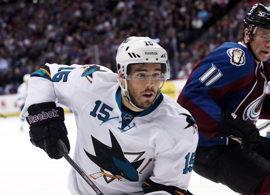 San Jose Sharks left wing James Sheppard, left, pursues puck towasrd the boasrds with Colorado Avalanche left wing Jamie McGinn in the second period of an NHL hockey game in Denver on Saturday, March 29, 2014. Sheppard was helped off the ice after being injured on the play. (AP Photo/David Zalubowski)
