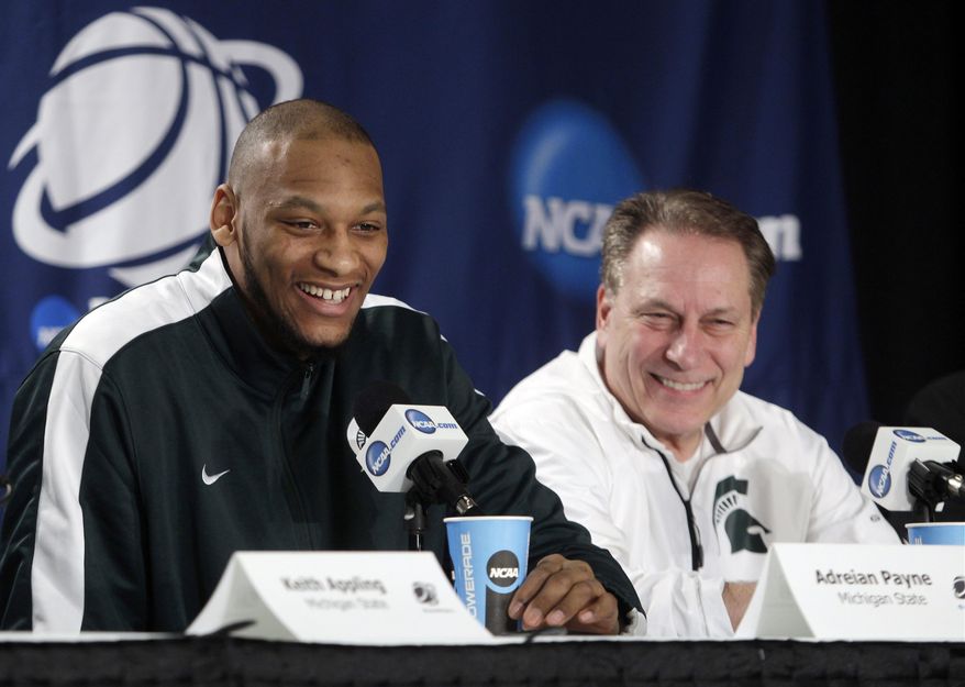 Michigan State's Adreian Payne, left, and head coach Tom Izzo react as Payene responds to a question during a news conference at the NCAA college basketball tournament Saturday, March 29, 2014, in New York. Michigan State plays Connecticut in a regional final on Sunday. (AP Photo/Frank Franklin II)