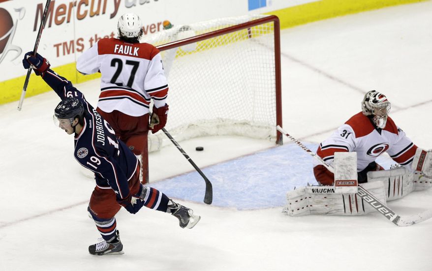 Columbus Blue Jackets' Ryan Johansen (19) celebrates his game winning goal against Carolina Hurricanes goalie Anton Khudobin (31), of Kazakhstan, as Hurricanes' Justin Faulk (27) looks on during overtime of an NHL hockey game in Raleigh, N.C., Saturday, March 29, 2014. Columbus won 3-2 in overtime. (AP Photo/Gerry Broome)