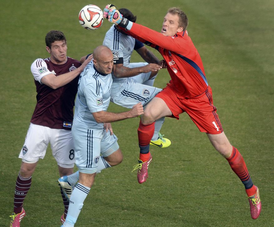 Sporting Kansas City goalie Eric Kronberg (1) punches the ball away from Colorado Rapids midfielder Dillon Powers (8) during the second half of an MLS soccer game Saturday, March 29, 2014, in Commerce City, Colo. (AP Photo/The Denver Post, Karl Gehring) NEW YORK POST OUT; NEW YORK DAILY NEWS OUT; MAGS OUT; TV OUT; NO INTERNET; NO SALES