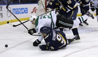 Dallas Stars&#39; Antoine Roussel falls over St. Louis Blues&#39; Jaden Schwartz while chasing the puck during the first period of an NHL hockey game Saturday, March 29, 2014, in St. Louis. (AP Photo/Jeff Roberson)