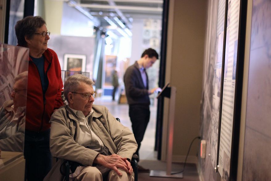 In this March 26, 2014 photo, Nancy and Charles Hardy read about the experience of Japanese-Americans sent to internment camps during World War II as they enter an exhibit titled “Barbed Wire to Battlefields” at the National World War II Museum in New Orleans. (AP Photo/Janet McConnaughey)