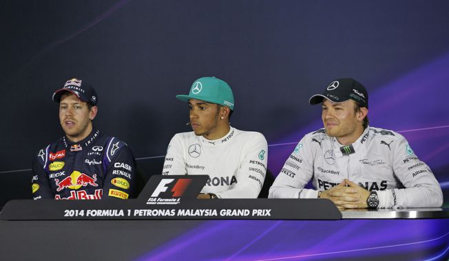 Red Bull Racing driver Sebastian Vettel, left, of Germany speaks as Mercedes drivers Lewis Hamilton, center, of Britain and Nico Rosberg, right, of Germany listen during a press conference after the qualifying session for Sunday&#x27;s Malaysian Formula One Grand Prix at Sepang International Circuit in Sepang, Malaysia, Saturday, March 29, 2014. Hamilton took the pole position while Vettel with second position and Rosberg with third position. (AP Photo/Peter Lim)