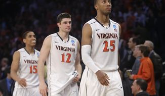 Virginia players, right to left, Akil Mitchell, Joe Harris, and Malcolm Brogdon leave the court after losing to Michigan State 61-59 in a regional semifinal at the NCAA men&#39;s college basketball tournament, early Saturday, March 29, 2014, in New York. (AP Photo/Frank Franklin II)