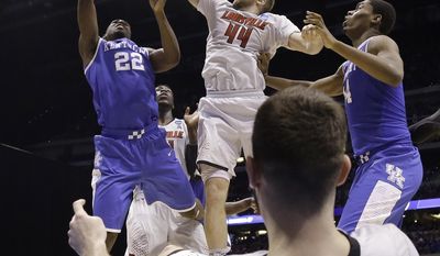 Kentucky&#39;s Alex Poythress (22) tries to shoot past Louisville&#39;s Stephan Van Treese (44) as Luke Hancock lays on the ground during the second half of an NCAA Midwest Regional semifinal college basketball tournament game Saturday, March 29, 2014, in Indianapolis. (AP Photo/David J. Phillip)